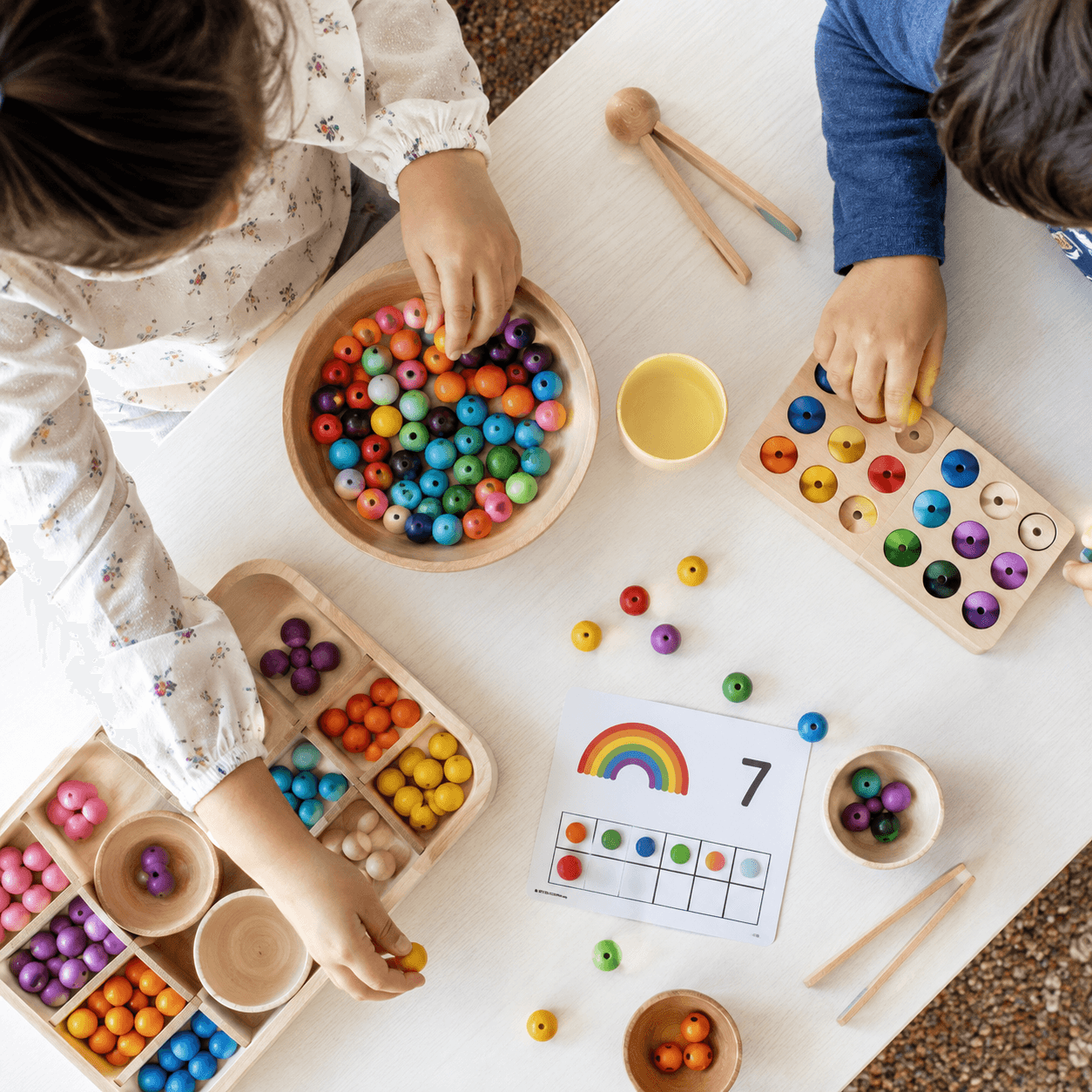 Children’s hands sorting colourful counting beads during purposeful play